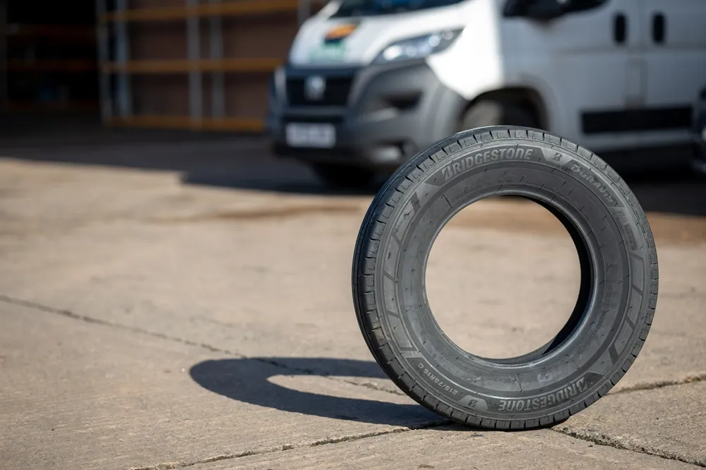 Bridgestone Duravis Van tyre positioned on a forecourt with a white van in the background