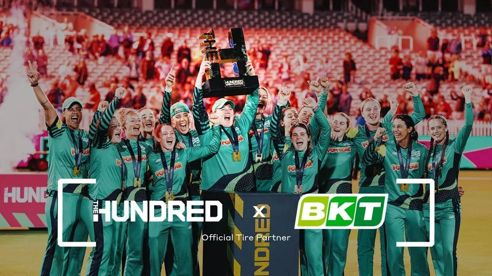 Image of a female cricket team celebrating a win wearing green kits