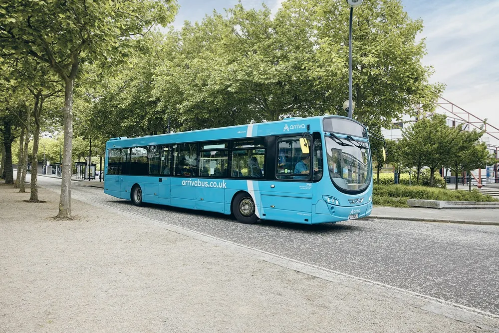 Blue Arriva Bus UK on a tree lined road