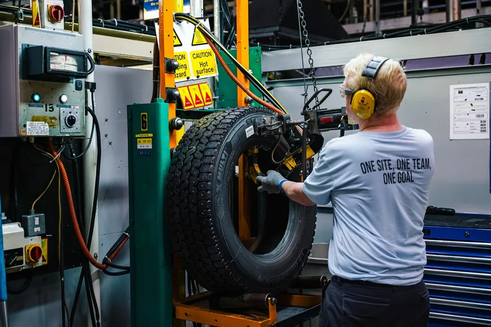 Image of a man working on a Michelin tyre on a machine