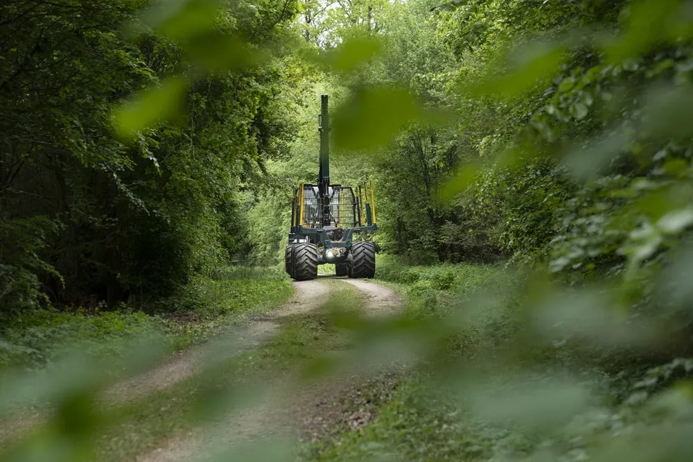 Image of forest equipment driving through on a forest path front view
